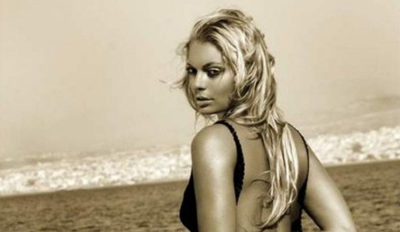 Lucie Borhyová v černých šatech sedí u moře