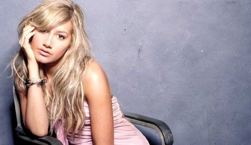 Ashley Tisdale sedí na židli v růžových šatech