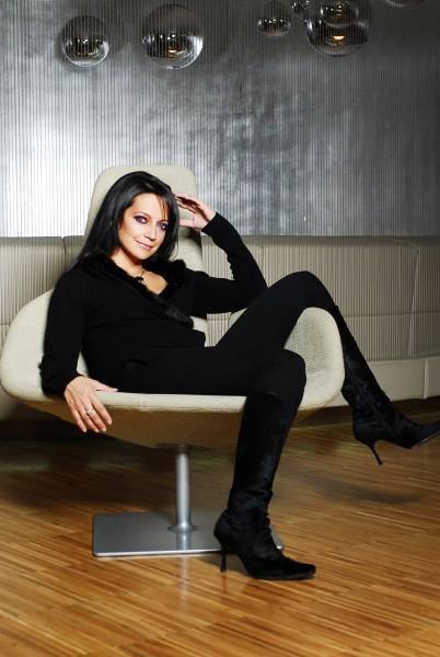 Lucie Bílá oblečená v černém sedící na bílé židli