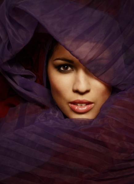 Hlava ženy v průsvitném fialovém šátku