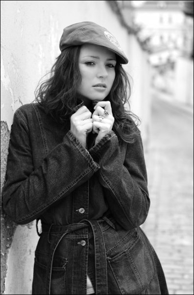 Fotografie ženy v kabátě s kšiltovkou na hlavě