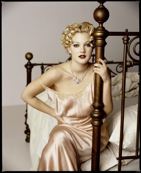 Drew Barrymore sedící na posteli