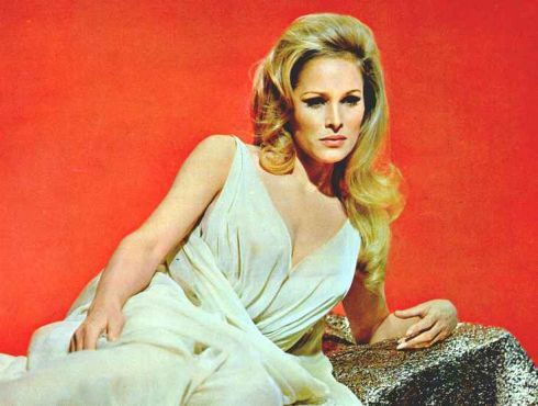 Ursula Andress v šatech na červeném pozadí