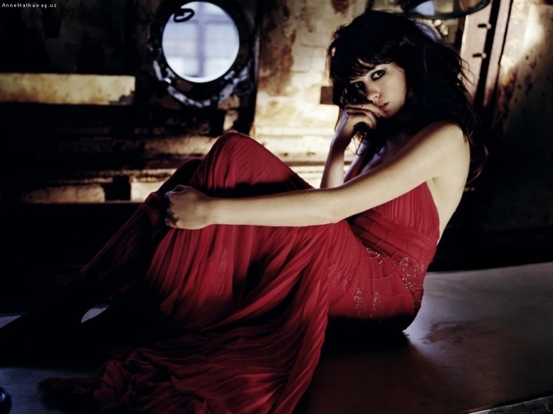 Anne Hathaway sedí v červených šatech