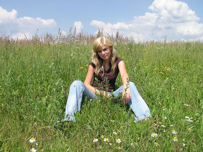 Nikol Štíbrová sedí na zelené louce