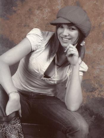 Kamila Nývltová s rukou pod bradou a úsměvem na tváři