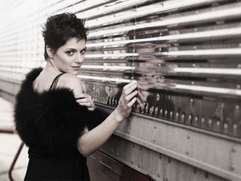 Černobílá fotografie Kláry Issové v černých šatech s kožešinou přes ramena