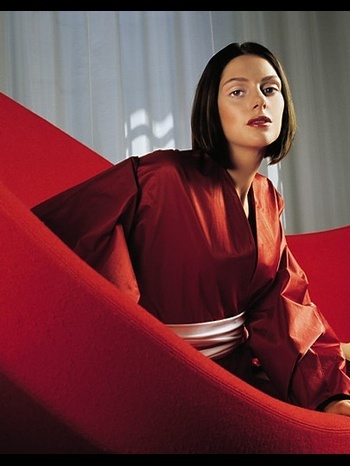 Klára Issová sedí ve velkém červeném křesle