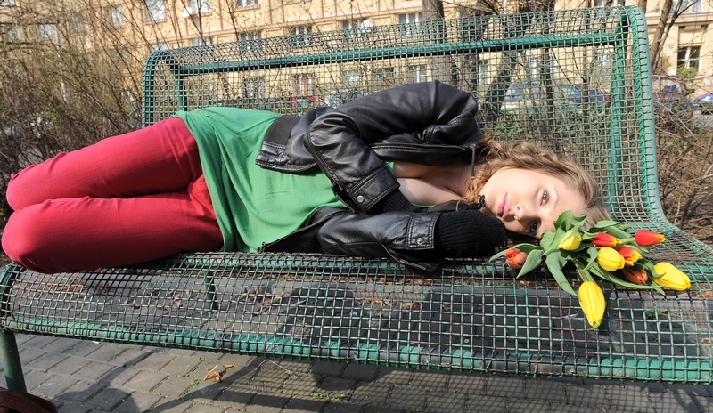 Lenka Zahradnická leží na lavičce s kyticí tulipánů