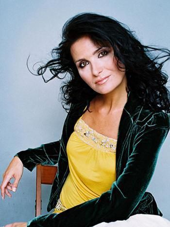 Michaela Maláčová sedí na židli v zeleném saku a žluté halence