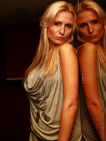 Romana Pavelková otočená zády k zrcadlu