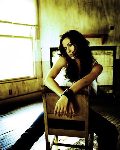 Alanis Morissette sedí na židli uprostřed místnosti