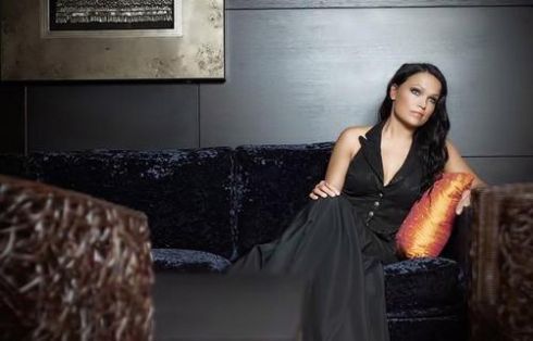 Tarja Turunen v černých šatech sedí na pohovce