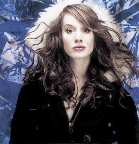 Žena s rozevlátými vlasy a černém kabátě