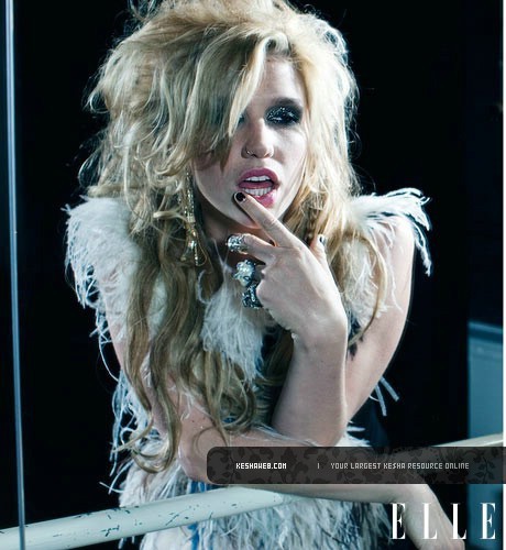 Kesha Sebert opřená o zábradlí s prstem na rtech