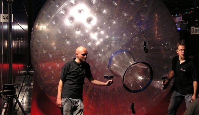 Muži ovládající nafukovací balón určený k zorbingu