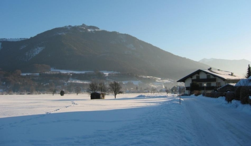 Fotografie zasněžené krajiny s pozadím hor