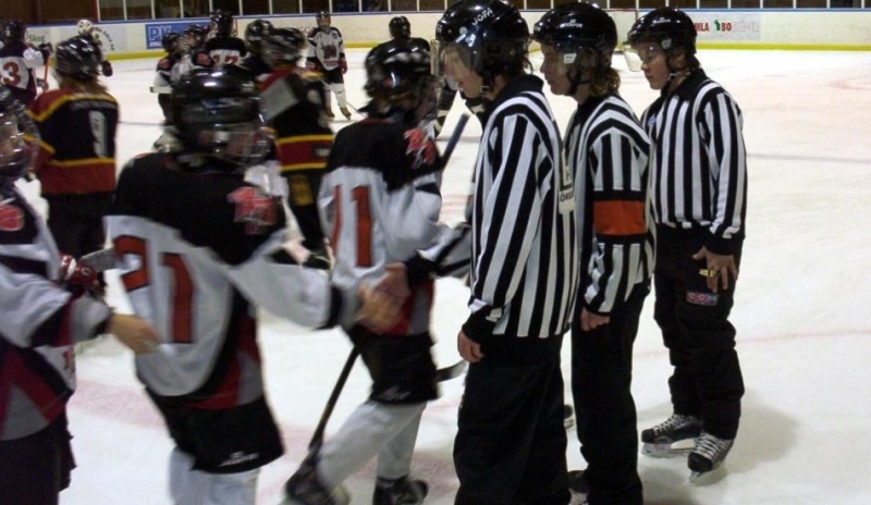 Hokejisti a rozhodčí na ledové ploše