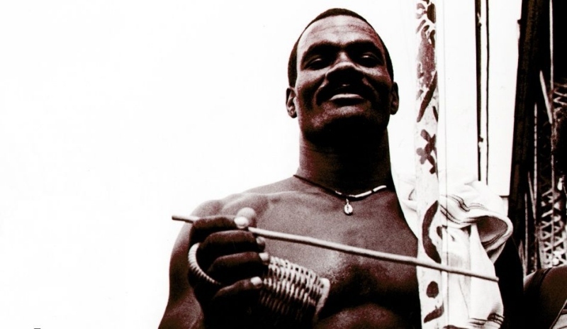 Fotografie zobrazující hráč na Berraboi, základní nástroj dodávájící tempo Capoeiře.