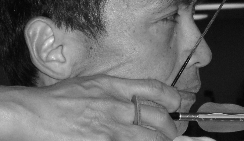 Černobílá fotografie muže s lukem v ruce