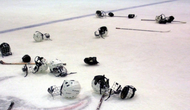 Přilby a hokejky na ledu