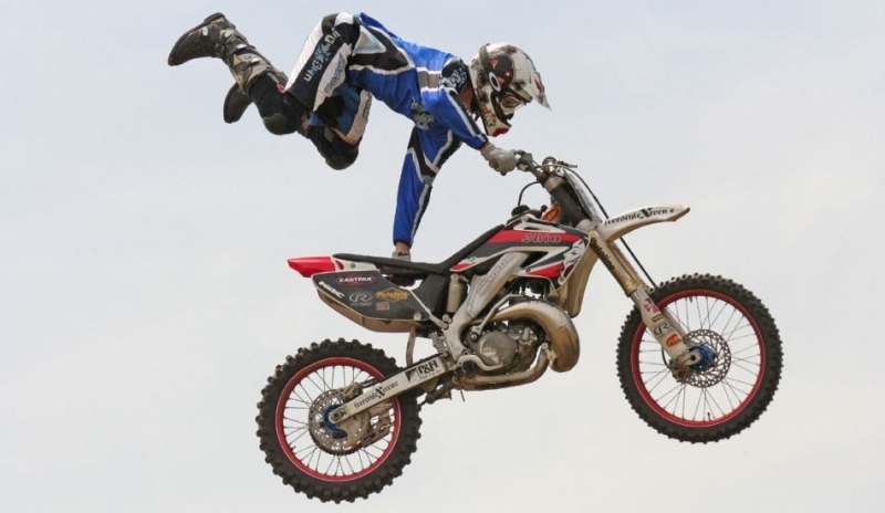 Závodník předvádí akrobatické kousky na motorce