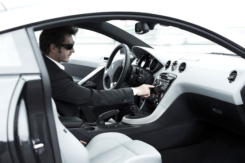 Muž sedící uvnitř vozu Peugeot RCZ