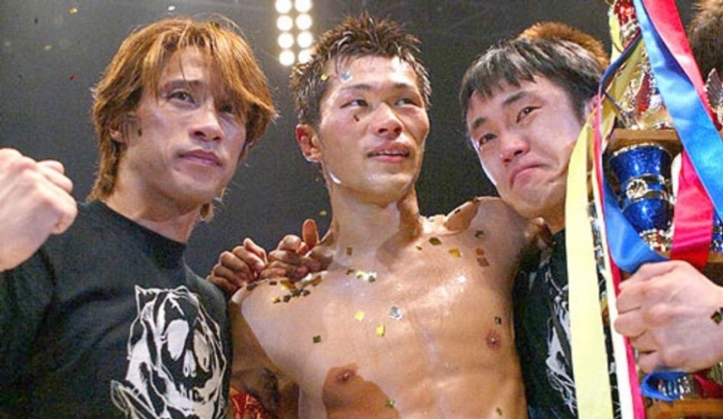 Fotografie tří mužů při vítězné oslavě