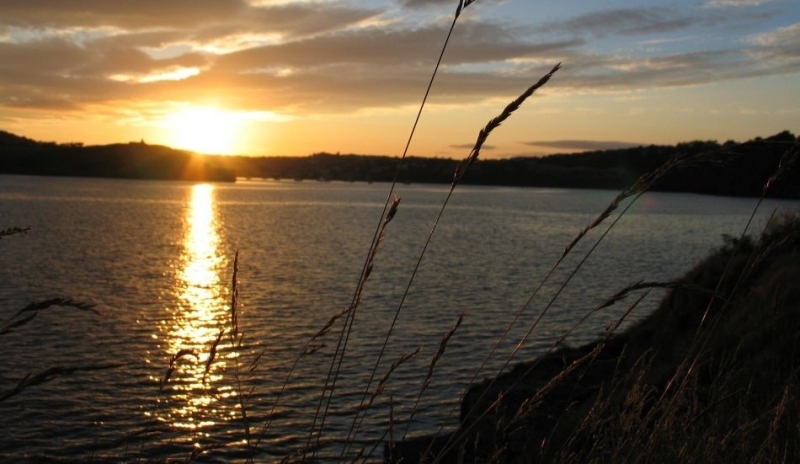 Pohled na vodní hladinu a zapadající slunce