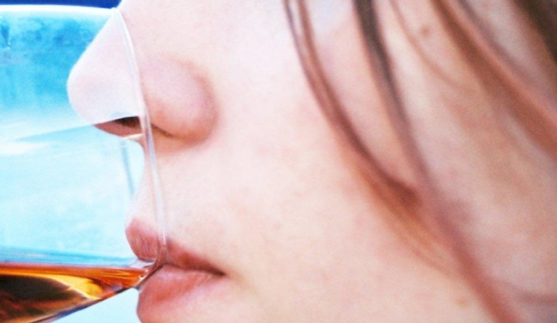 Detailní záběr na ženu se sklenicí u pusy