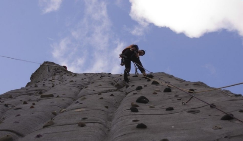 Muž šplhající na vrchol hory