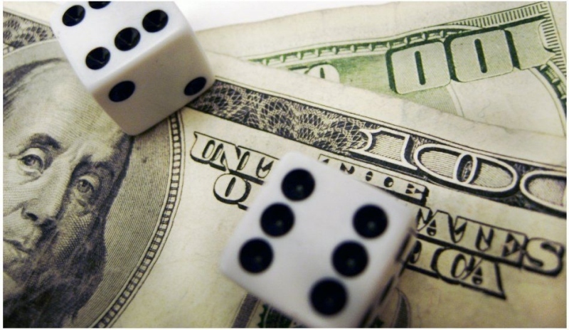 Fotografie dvou kostek s číslem šest a bankovek