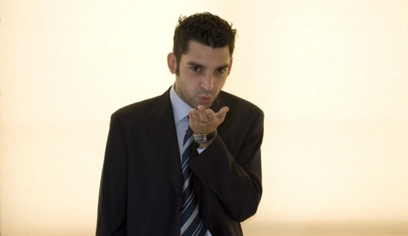 Snímek muže v obleku foukající na ruku