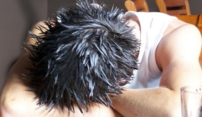 Fotografie muže s hlavou na rukou