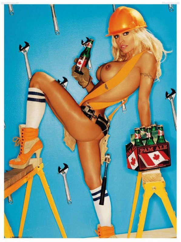 Nahá modelka s přilbou na hlavě a lahví v ruce