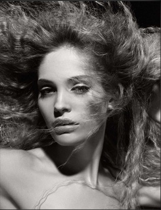 Černobílá fotografie ženy s rozevlátými vlasy