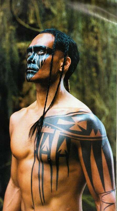 Obrázek muže se zapletenými copánky a tetováním