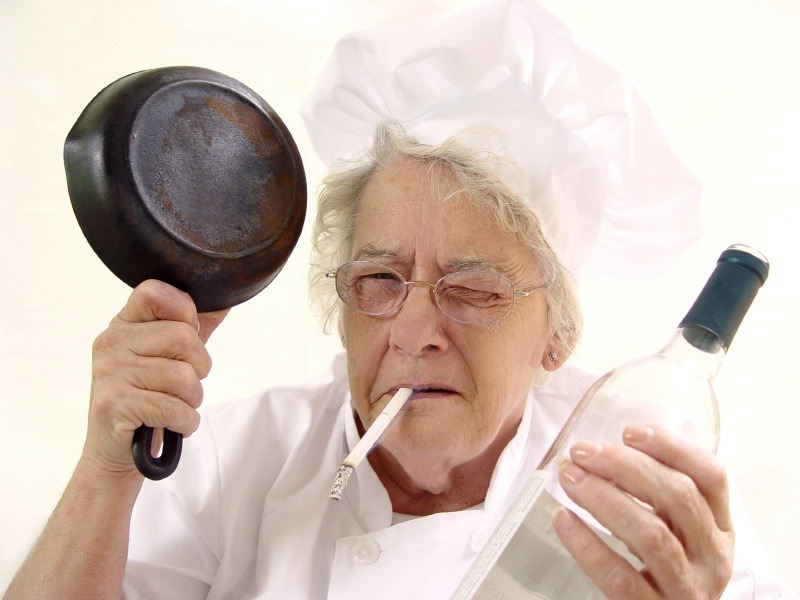 stará kouřící žena s pánvičkou a alkoholem