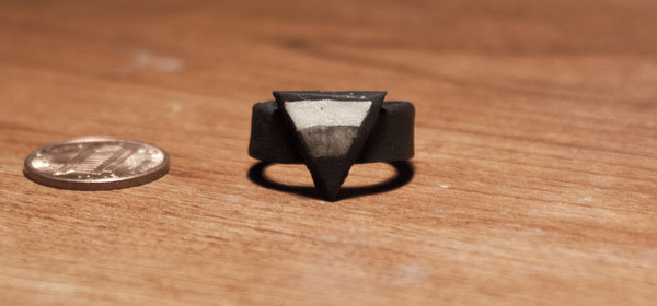 Prsten s mincí na dřevěném povrchu