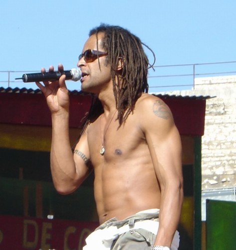 Yannick Noah ve slunečních brýlích s mikrofonem v ruce