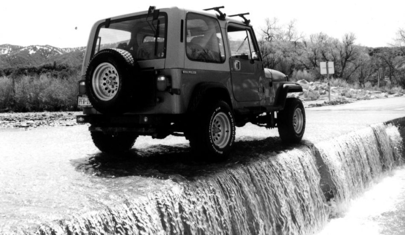 Jeep projíždějící zaplavenou cestou