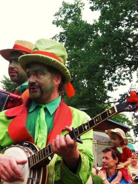 Muž v masce vodníka hraje na banjo.