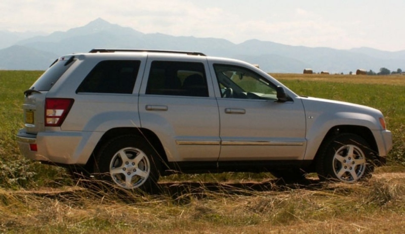 Automobil Jeep Grand Cherokee zaparkovaný na polní cestě