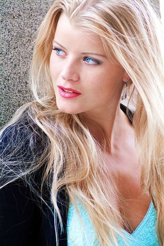 Blondýna opírající se o zeď