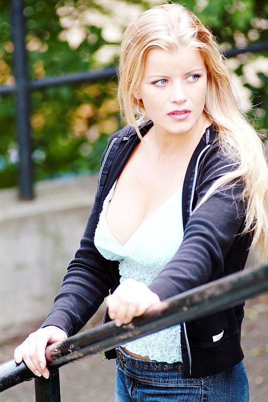 Žena s dlouhými blond vlasy se drží zábradlí