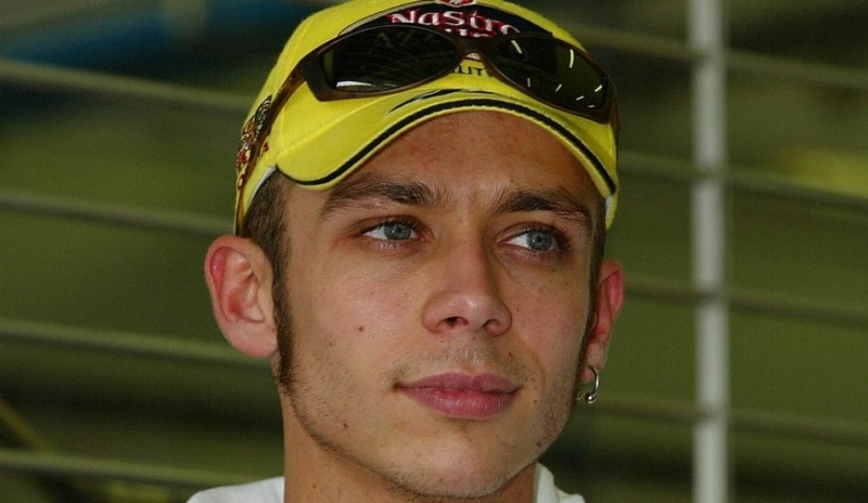 Motocyklový závodník Valentino Rossi  ve žluté kšiltovce s černými brýlemi