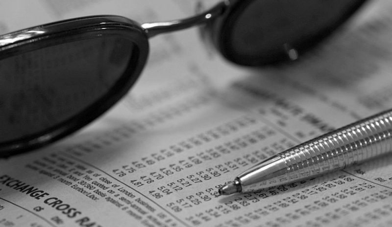 Snímek směnného kurzu, slunečních brýlí a propisky