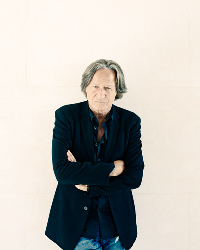 Obrázek muže v tmavém saku s prošedivělými vlasy