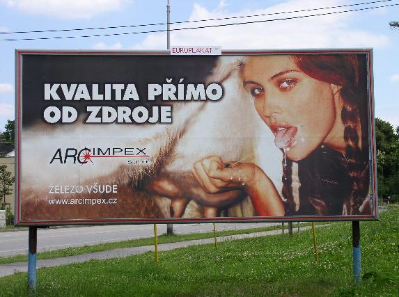 Žena na bilboardu s vyplazeným jazykem si stříká mléko do pusy