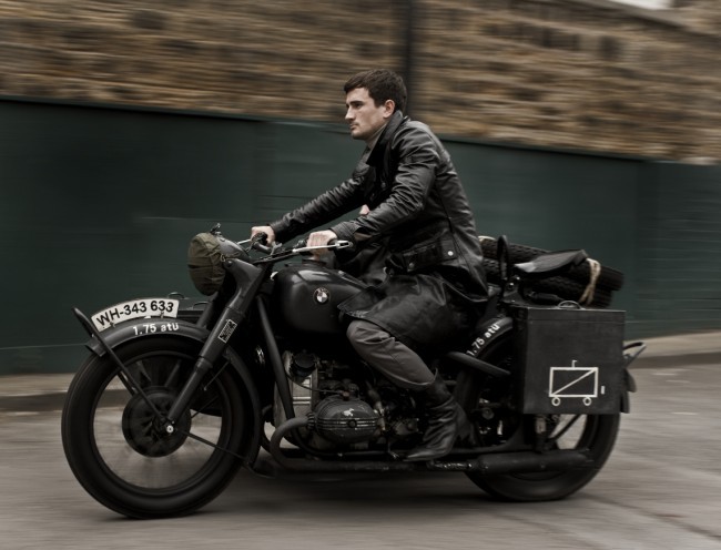 Muž sedí v koženém kabátě na motocyklu